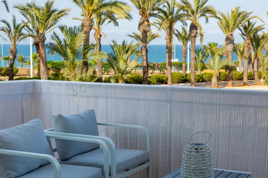 a balcony with two chairs and palm trees at Casa Victoria · Golf, Sun and Sea Breeze. Mojácar in Mojácar