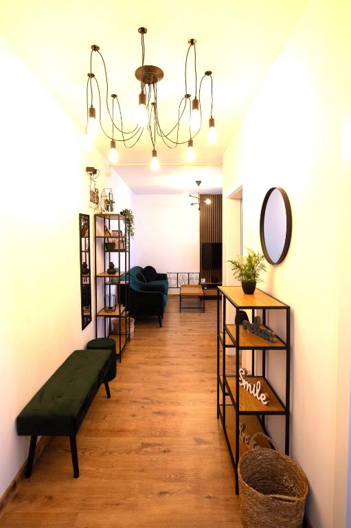a living room with a chandelier and some shelves at Izium Central Residence in Baia Mare
