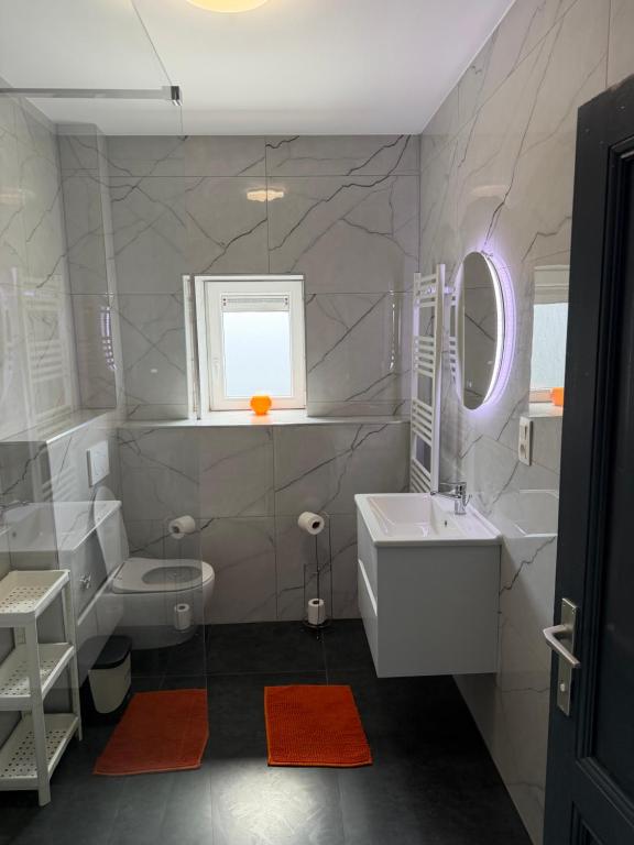 a white bathroom with a sink and a toilet at Ans soleil in Ans