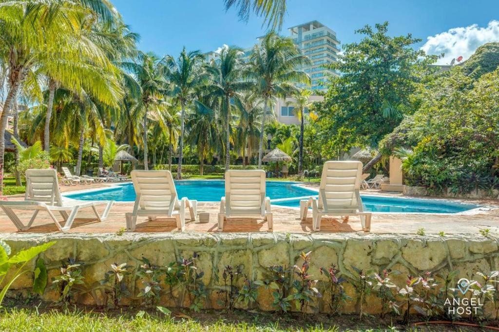 a group of lounge chairs next to a swimming pool at Suites Marea in Cancún