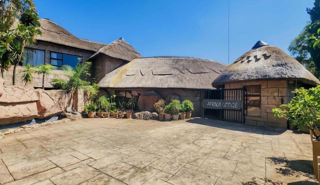 a house with a thatched roof at Afrika Lodge in Kempton Park