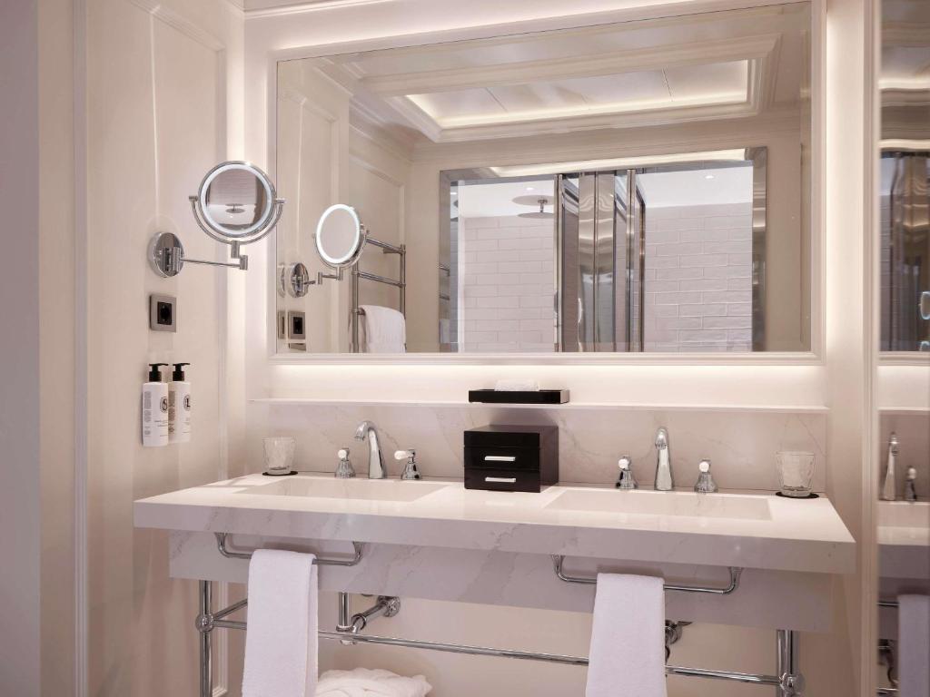 a white bathroom with a sink and a mirror at Sofitel Barcelona Skipper in Barcelona