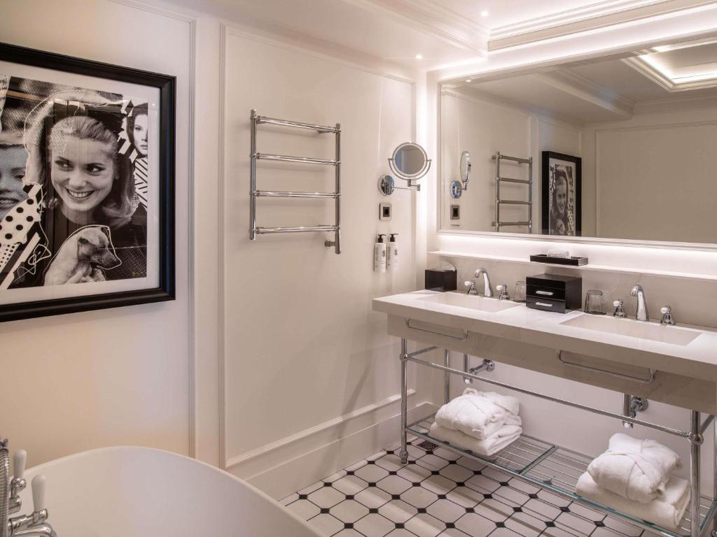 a bathroom with a sink and a large mirror at Sofitel Barcelona Skipper in Barcelona