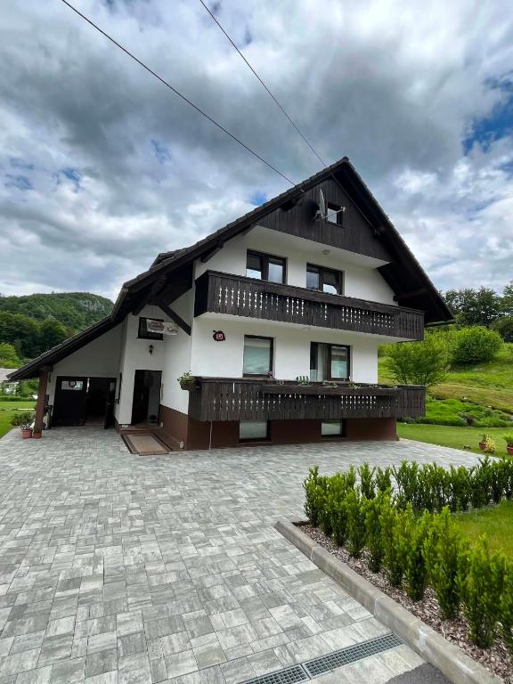a large white house with a black roof at Bohinjski kot in Bohinj