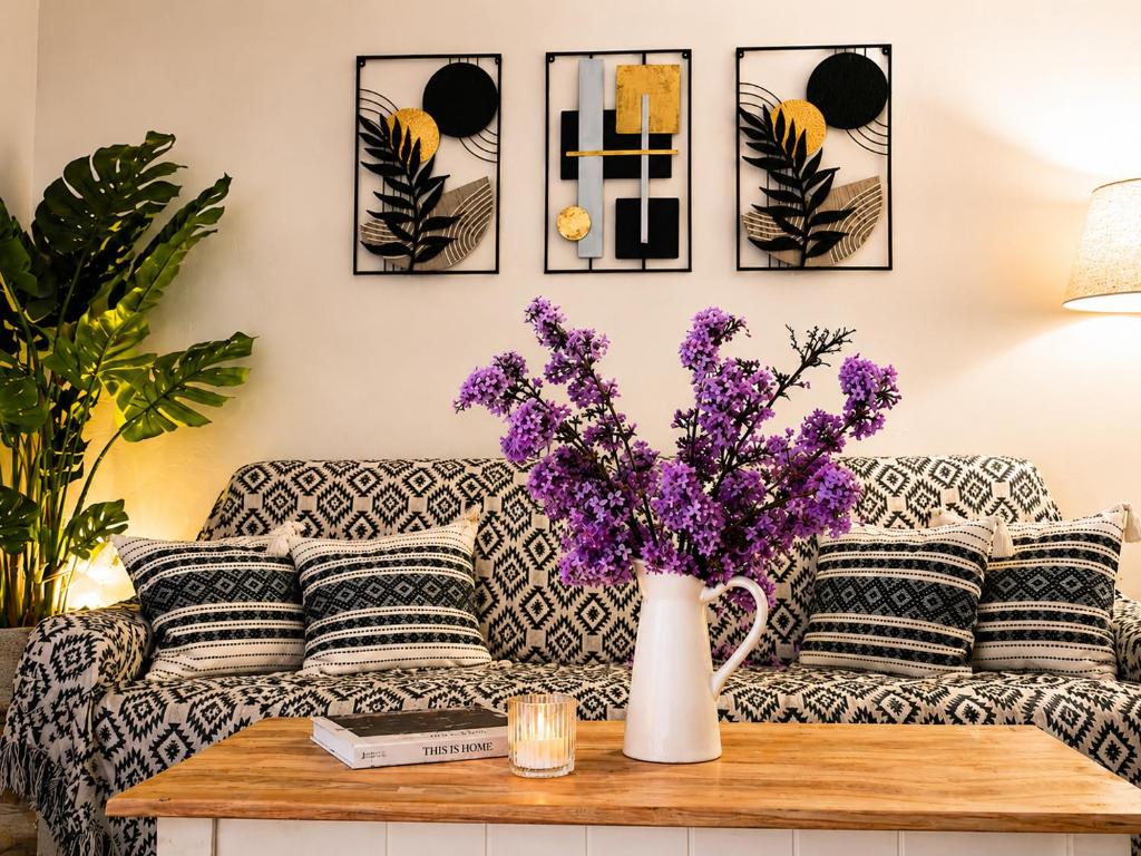 a living room with a couch with purple flowers on a table at Evanthia's House in Arianá