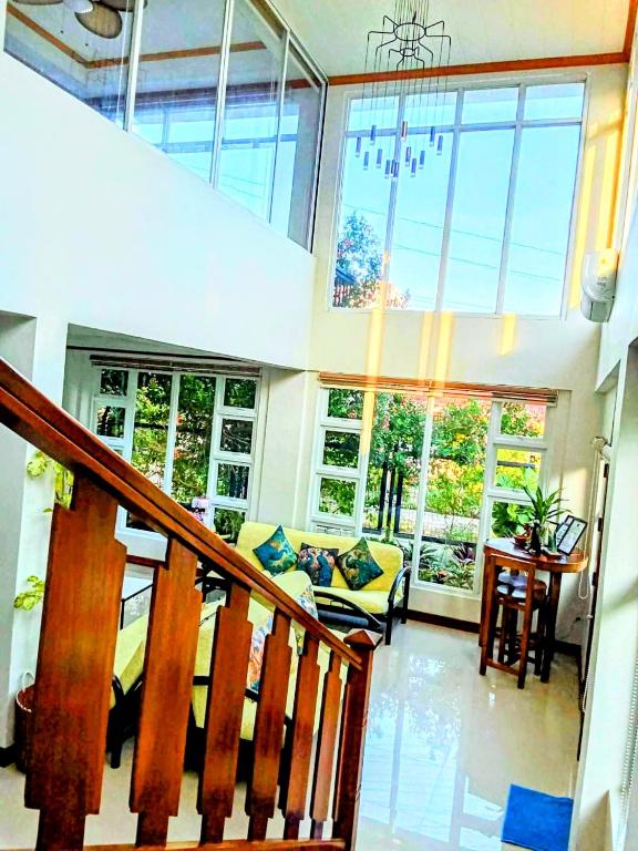 a living room with a staircase and a couch in a house at KRUEGERs Cottage in Sipalay