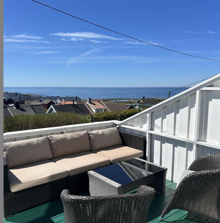a balcony with a couch and chairs and the ocean at Ocean panorama in Farsund