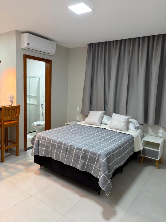 a bedroom with a large bed and a bathroom at Residencial Bom Sossego Apto 01 in Itabuna