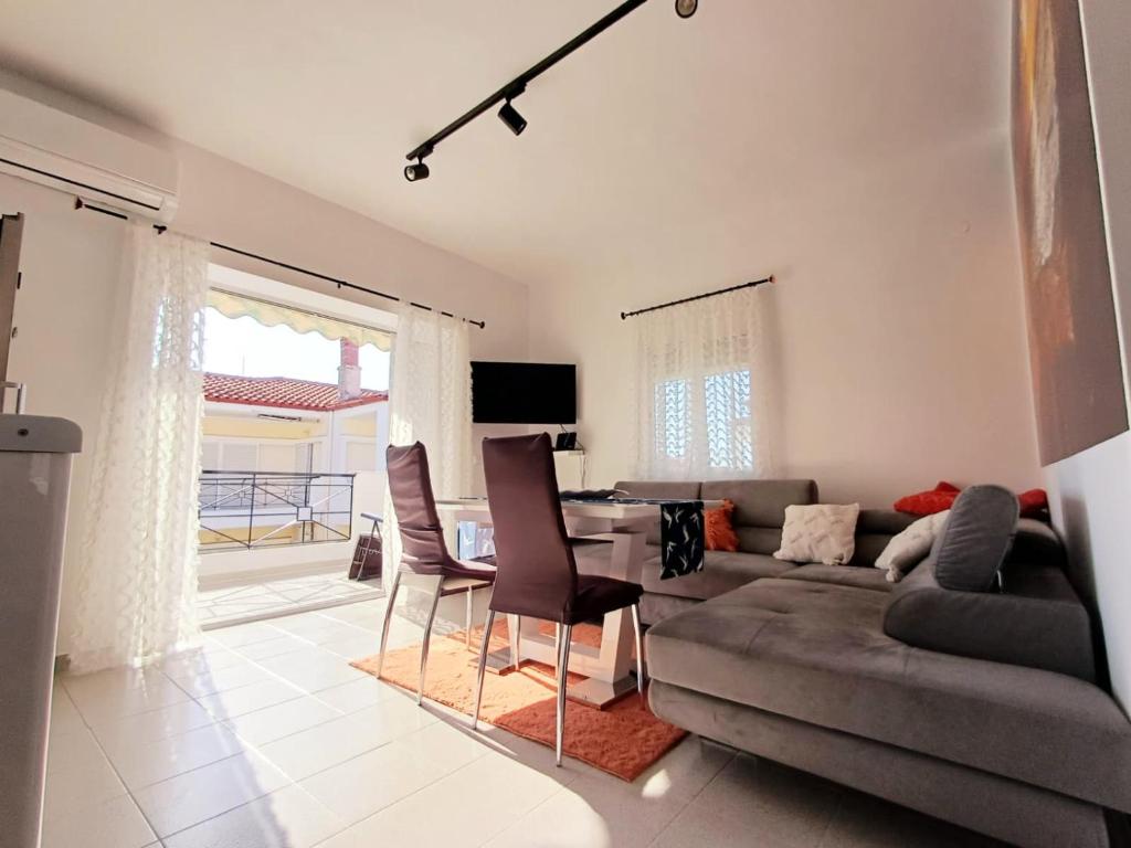 a living room with a couch and a table and chairs at Apartament Słoneczny in Skala Fourkas
