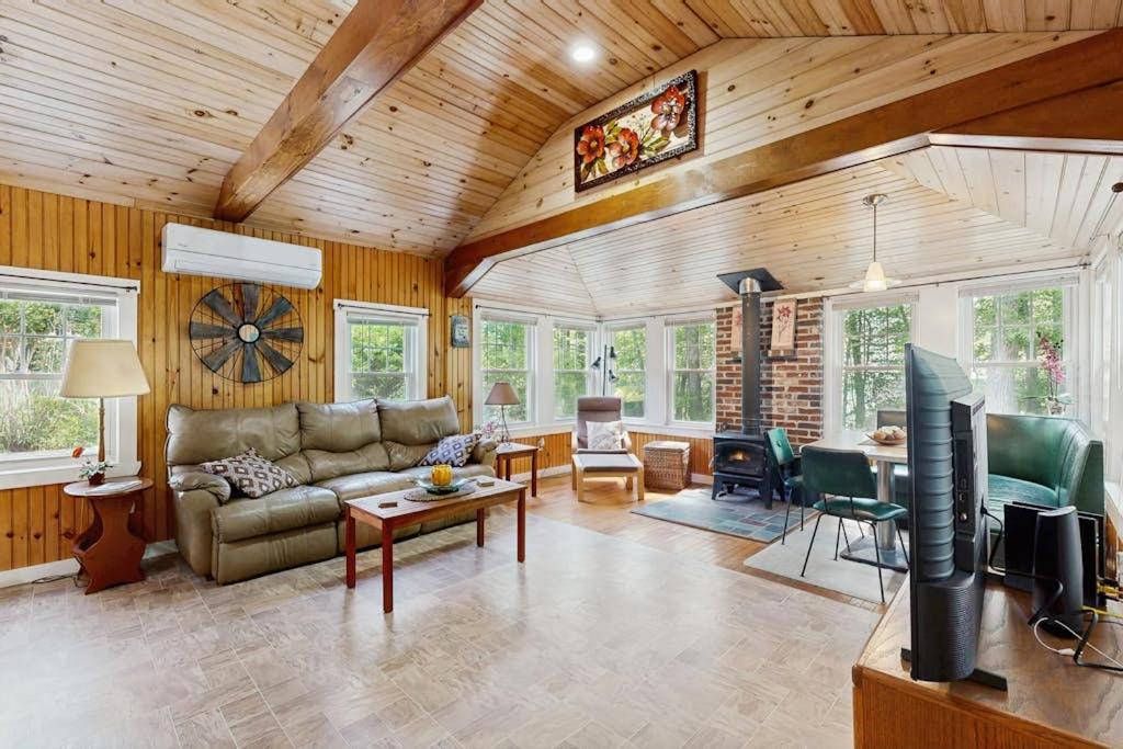 a living room with a couch and a table at Sebago Shores Cottage in North Sebago