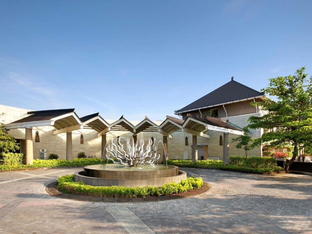 a building with a fountain in front of a building at Mercure Bali Nusa Dua in Nusa Dua