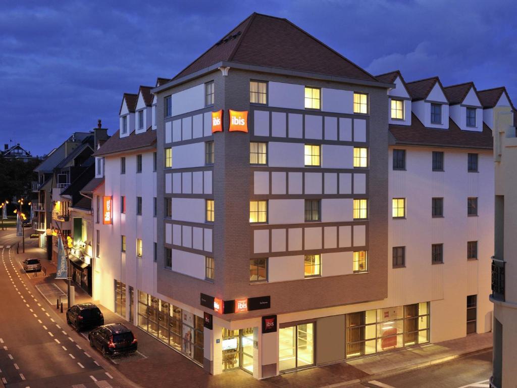 a large white building with a black roof at ibis De Panne in De Panne