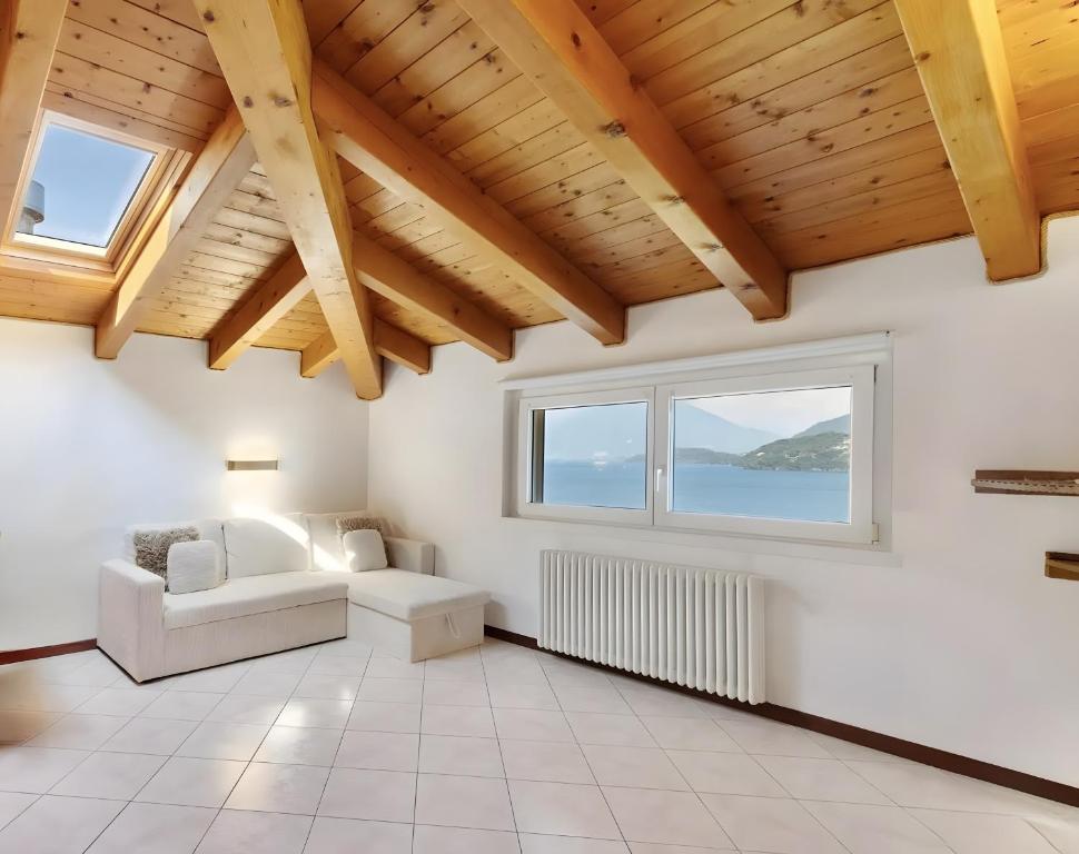 a living room with a white couch and a window at Mansarda Spadone in Musso