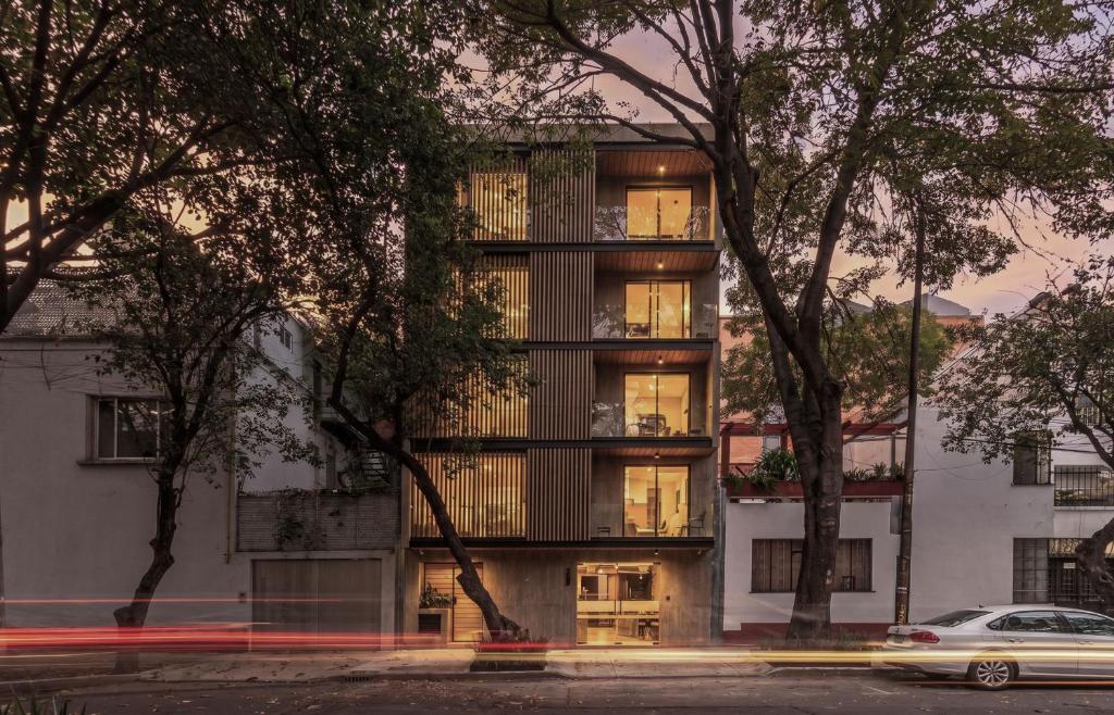 an apartment building with lights on in a city at Casa Grijalva by Kukun Apartments in Mexico City