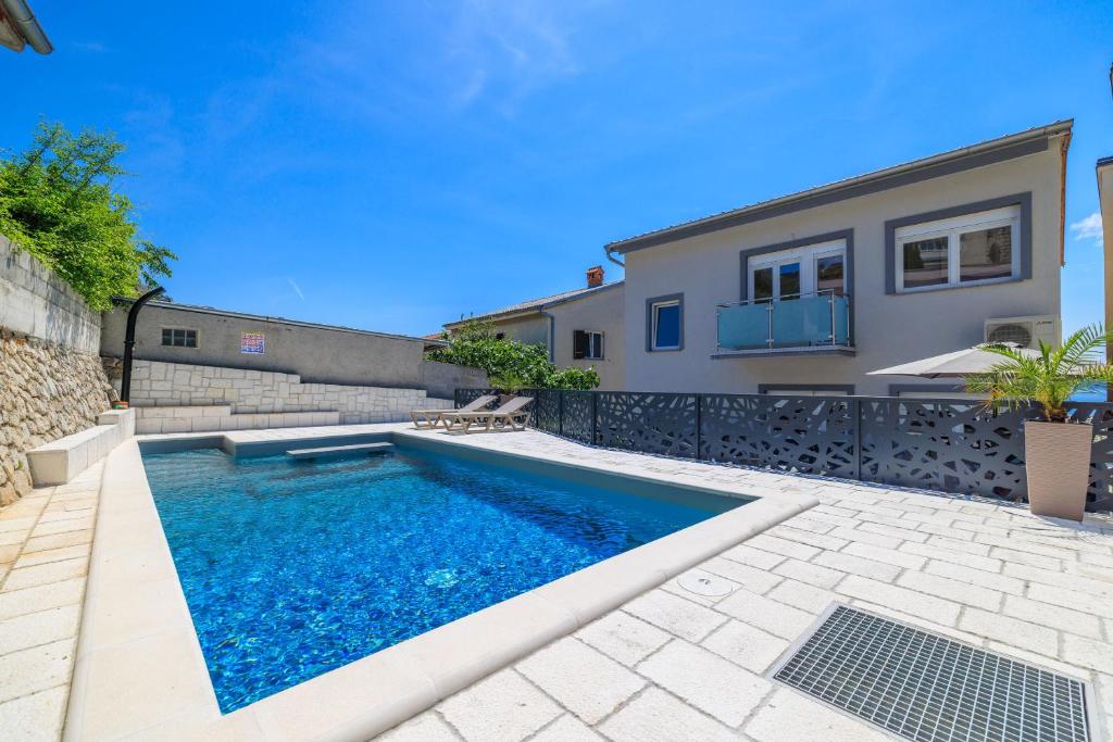a swimming pool in the backyard of a house at Apartments Maja in Selce