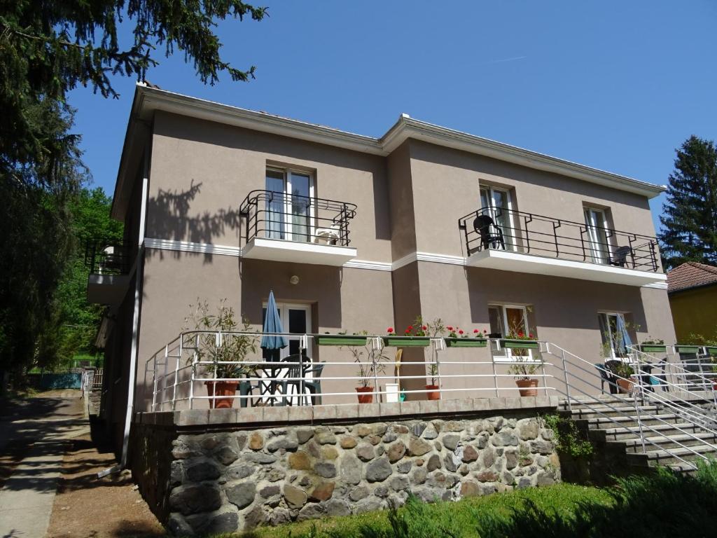a house with balconies on a stone wall at Boróka Panzió in Parád