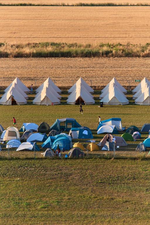 a group of tents in a field with people in it at NIBIRU OFFICIAL ACCOMMODATION LUNR Camp in Costinesti