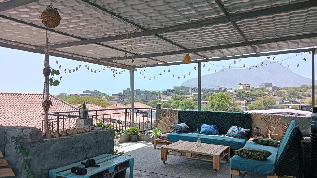 a patio with a blue couch and a table at Ka'Zinha Guesthouse - Chambres d'hôtes Tarrafal in Tarrafal