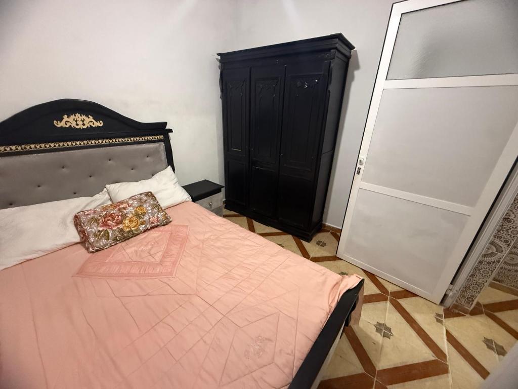 a bedroom with a bed with a black headboard at Katalan in Martil