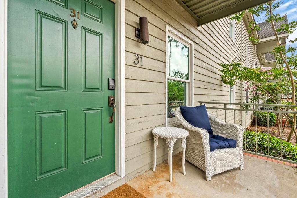 a green door and a chair on a porch at Saturdays In The South in Auburn