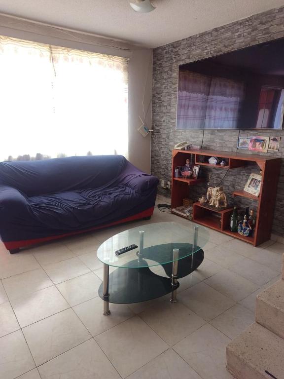 a living room with a couch and a glass table at House near AIFA in San Cristóbal