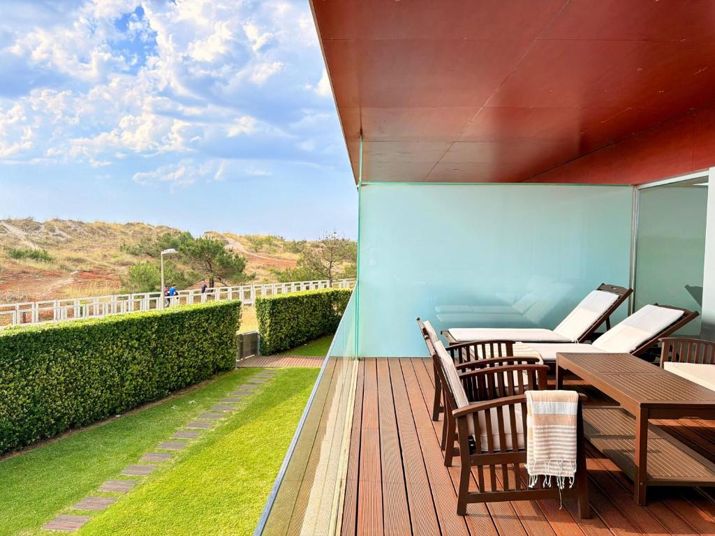 a deck with tables and chairs on a balcony at T2 Dunas Esposende in Esposende