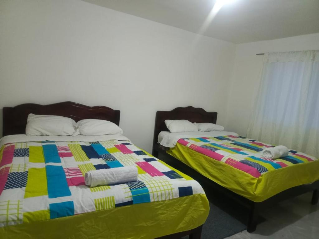 two beds sitting next to each other in a bedroom at Hotel CasaBlanca"Tablon de miraflores" in Cuenca