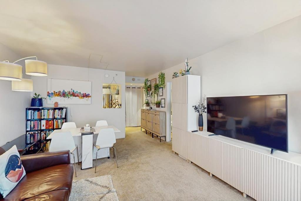 a living room with a couch and a dining room at City Lights at Newmark - World Cup Availability in Seattle
