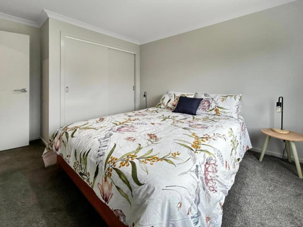 a bedroom with a bed with a floral bedspread at Snapper Cabin in Portland