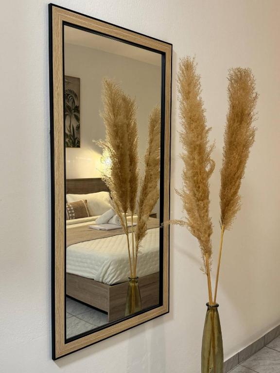a mirror on a wall with two vases at Avlή Apartments I in Kamári