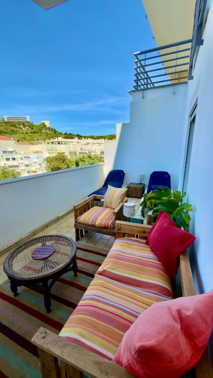 a balcony with two couches and a table on a building at Ilumina Hostel Albufeira in Albufeira