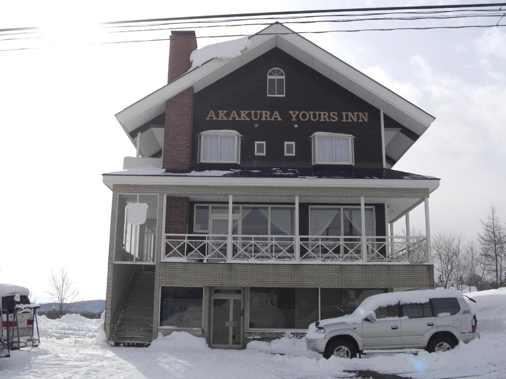 a house with a truck parked in front of it at Akakura Yours Inn in Myoko