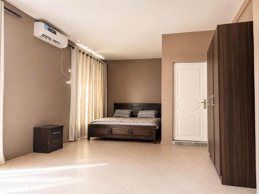 a bedroom with a bed and a window and a door at Kiki bay in Conakry