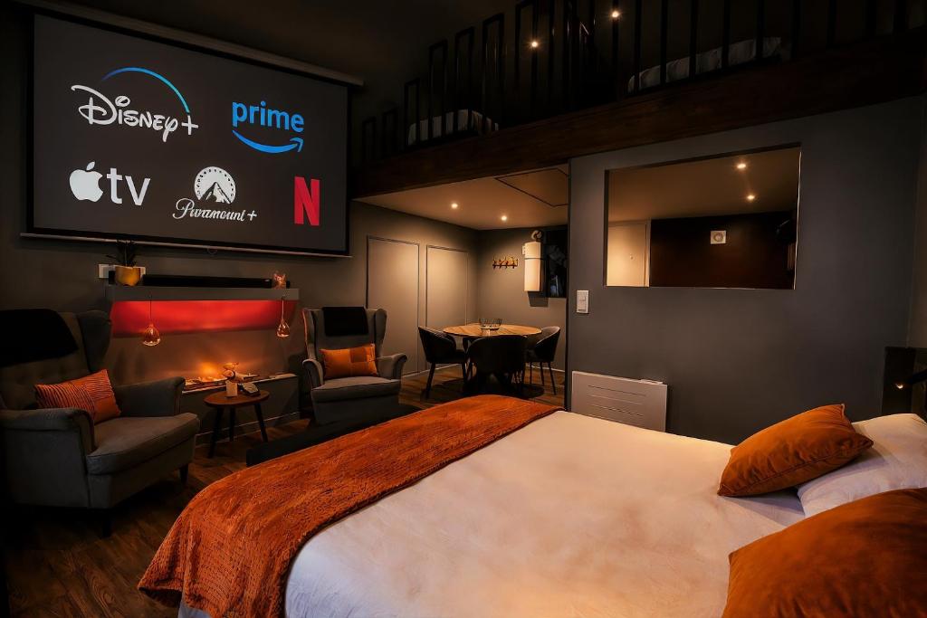 a bedroom with a large bed and a dining room at Suite Phoenix - Maison Cosy avec Terrasse & Cinéma Privé in Angoulême
