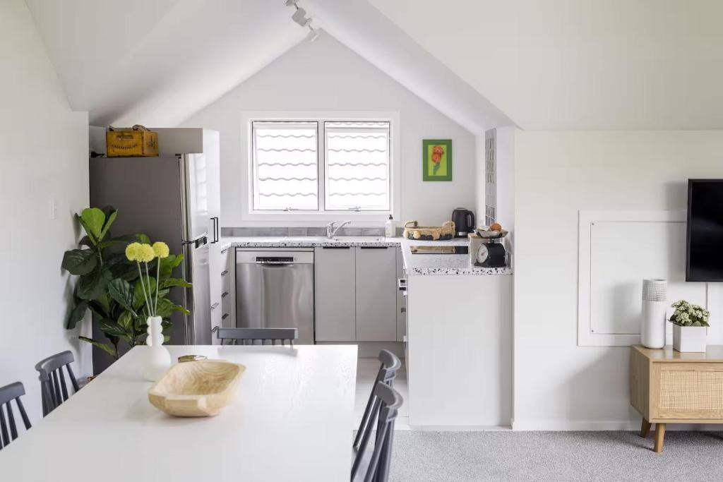 a white kitchen with a table and a refrigerator at The Stables in Newstead