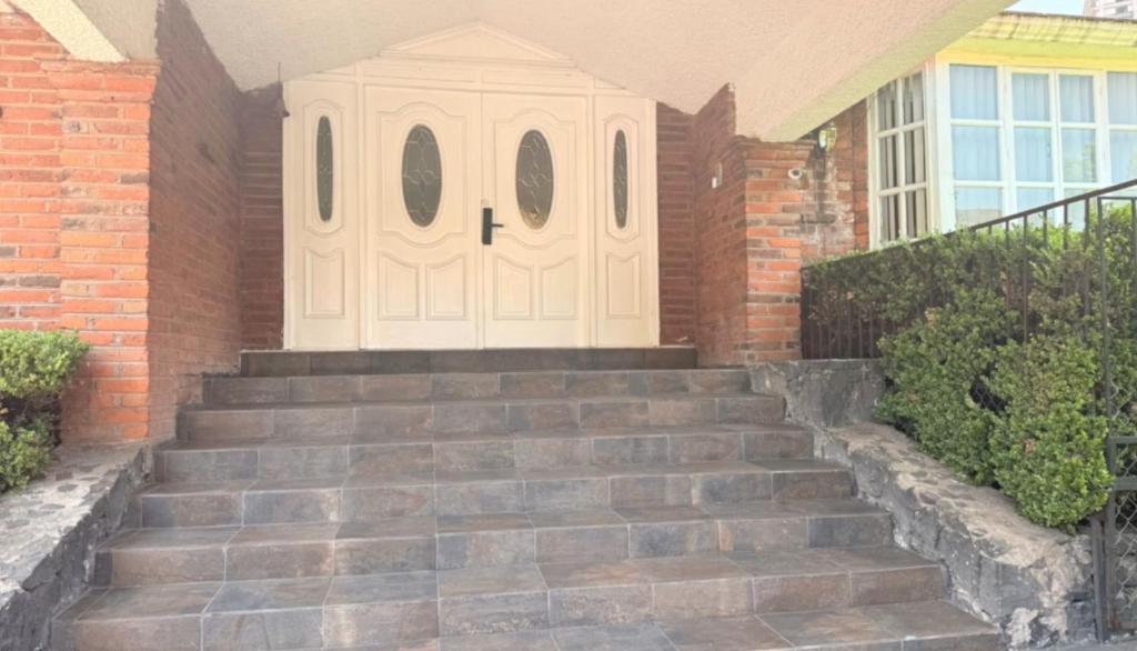 a set of stairs leading to a white door at Habitacion en residencia compartida in Mexico City