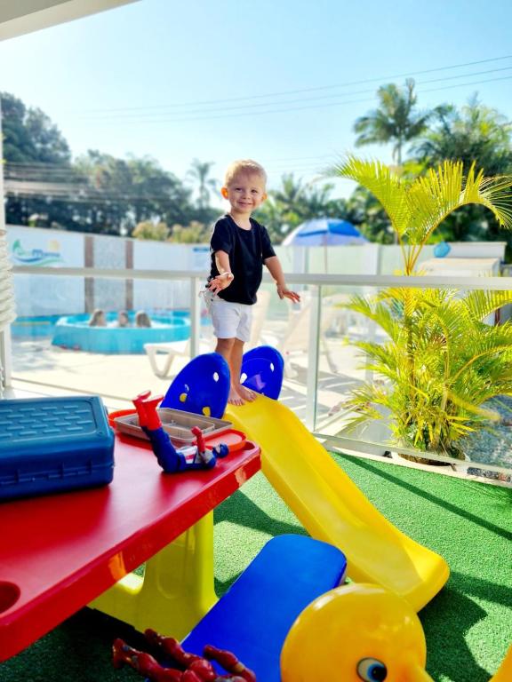 a young boy is playing in a playground at Ecomarine Apart-hotel 800 m Beto Carrero in Penha