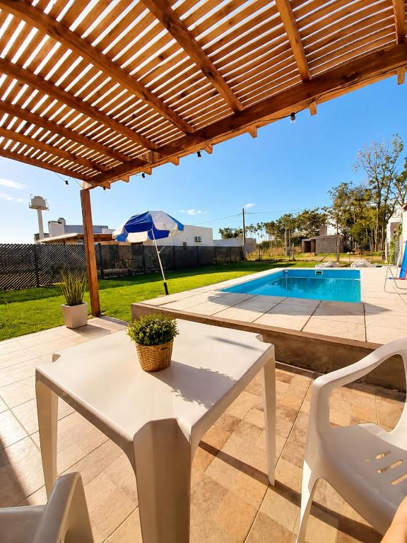 a patio with a white table and chairs and a pool at Rincón Joven II in San Miguel del Monte
