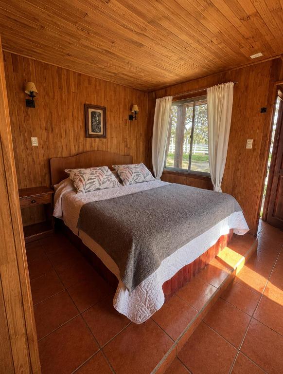 a bedroom with a bed in a wooden room at Turismo La Isla in Salto del Laja