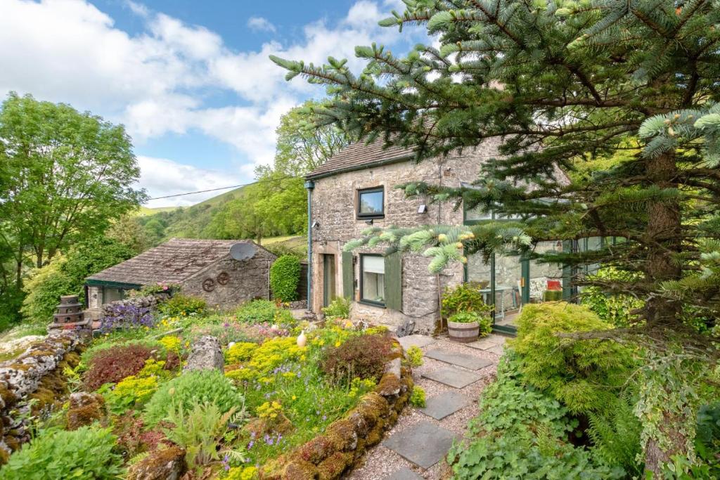 a stone house with a garden in front of it at 2 Bed in Buxton oc-dcbap in Longnor