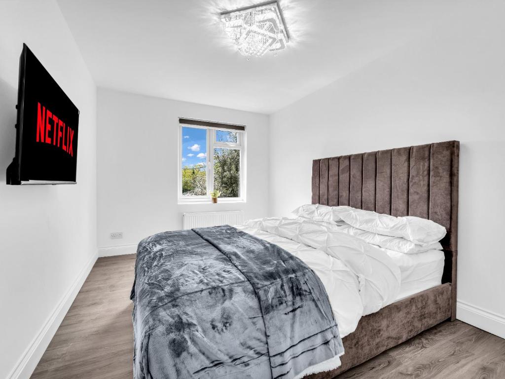 a bedroom with a large bed in a white room at LODGEselect in Thamesmead