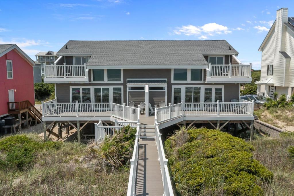 a house on the beach with a boardwalk at Oceanfront vacation home - EAST in Emerald Isle