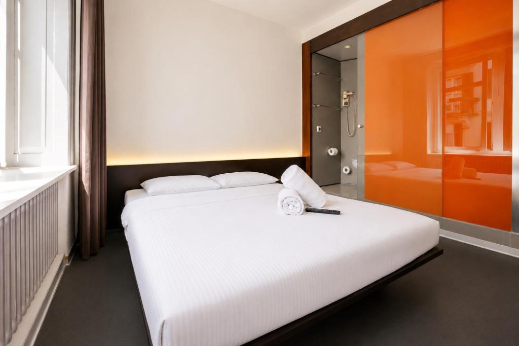 a bedroom with a large white bed and a bathroom at easyHotel Zürich City Centre in Zurich