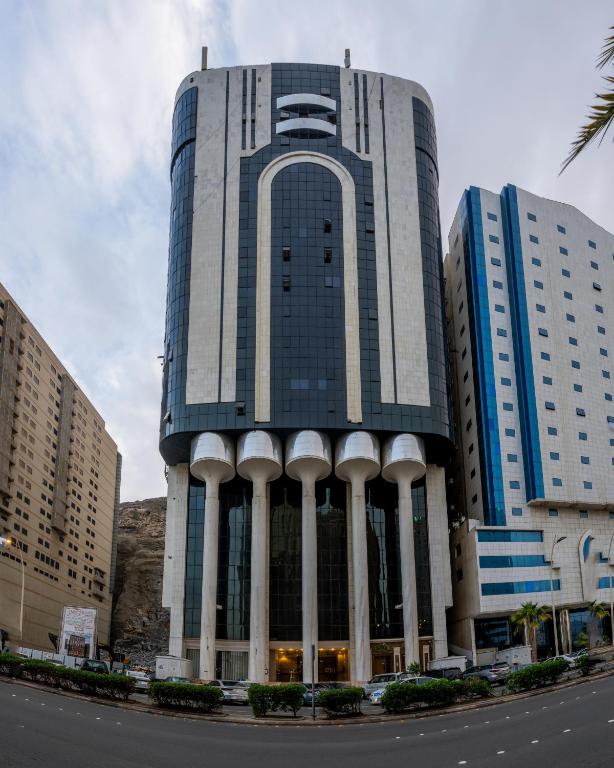 a tall building with columns in front of a street at عالم الضيافة in Al ‘Azīzīyah