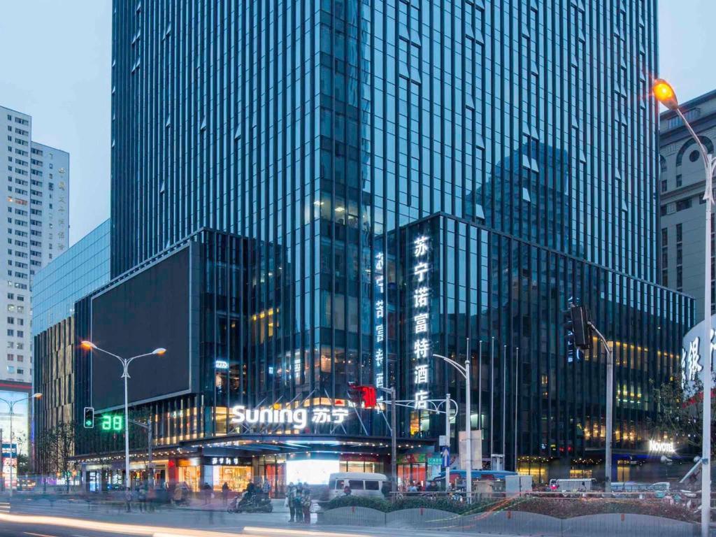 a large glass building in a city at night at Novotel Nanjing Central in Nanjing