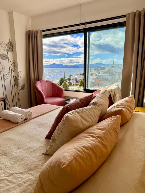 a room with a large bed with a large window at Studio Mirador in San Carlos de Bariloche