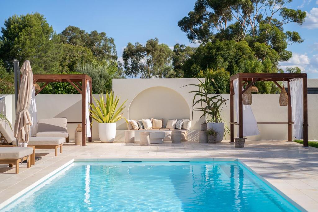a swimming pool in a backyard with a couch and a table at Barossa Palms Motel in Nuriootpa