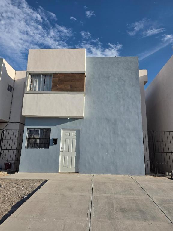 a white house with a white door and a fence at Casa VP en Fraccionamiento in Ciudad Acuña