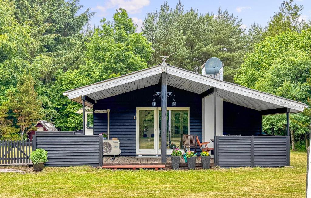 a small blue house with a porch and a porch at Spætten in Brovst