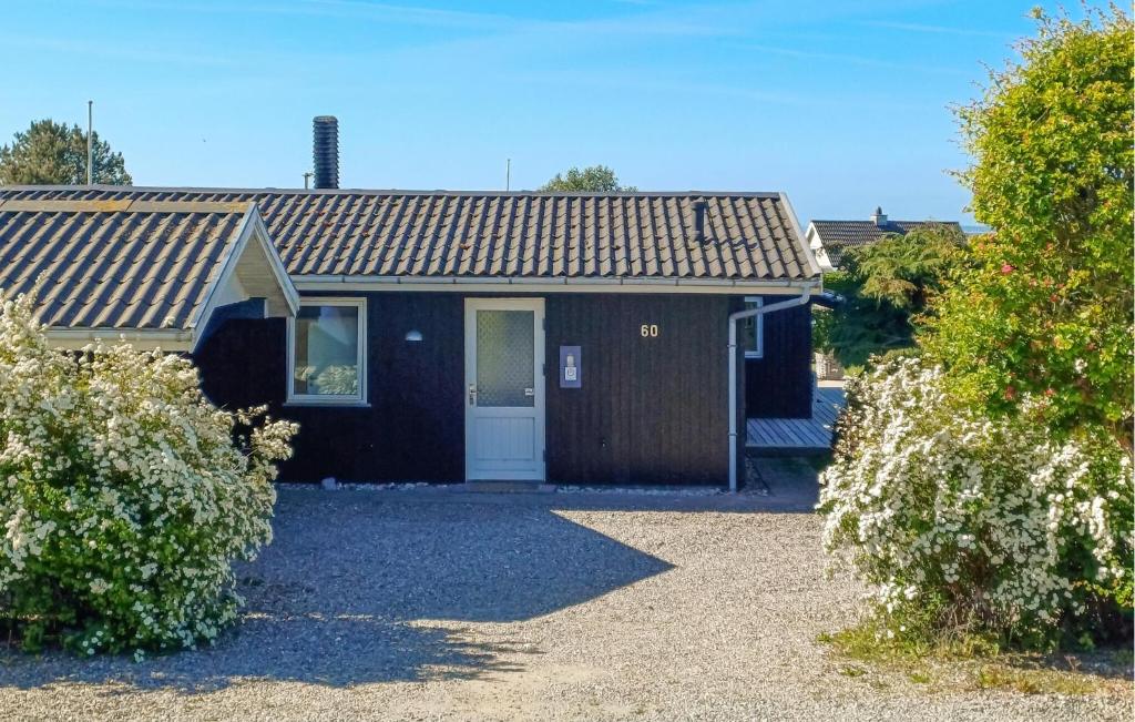 a small black house with a white door at Awesome Home In Haderslev With Wifi in Haderslev